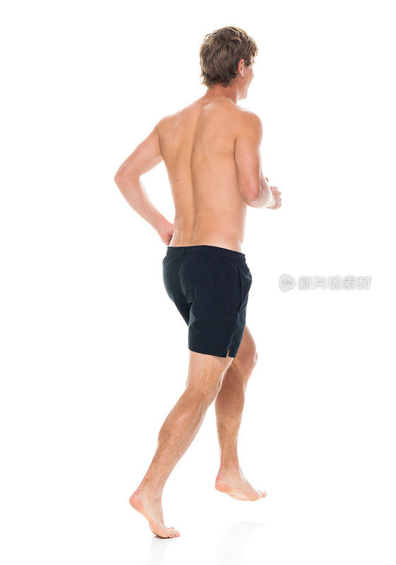 全身/后视图20-29岁英俊的人白人男性/年轻男子运动员/运动员跑步/锻炼/慢跑/短跑/短跑在白色背景穿着运动服/跑步短裤/短裤/运动